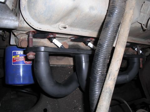 1991 Ford Bronco - Close-up view of engine components including an exhaust manifold and oil filter.