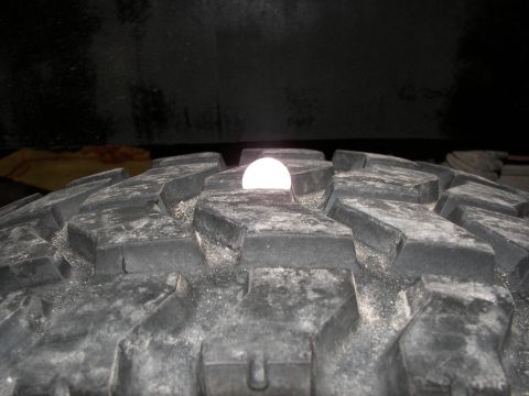 1990 Chevrolet Suburban - A white object is visible in the deep grooves of a heavy-duty tire tread.