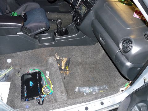 2006 Ford E350 - The interior of a vehicle shows a Soundstream Stealth amplifier installed on the carpeted floor.
