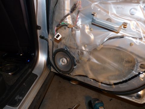 2006 Ford E350 - Interior of a car door with the speaker removed, revealing wiring and the inner door structure.