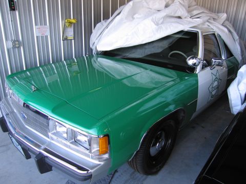 1991 Ford Crown Victoria LTD - This 1991 Ford Crown Victoria LTD police car is seen in a garage, partially covered by a car cover.