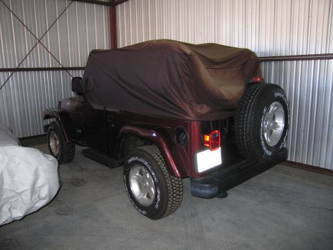 1991 Ford LTD Crown Victoria - A Jeep Wrangler is parked inside a metal garage, partially covered by a brown car cover.