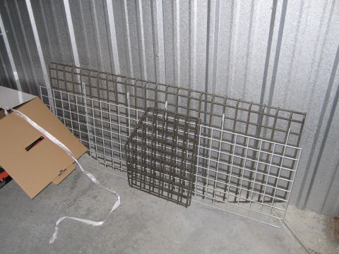 1991 Ford LTD Crown Victoria - Several wire mesh panels and cardboard boxes are stored against a corrugated metal wall in a storage unit.