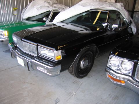 1991 Ford LTD Crown Victoria - A black 1991 Ford Crown Victoria LTD is parked in a garage, partially covered by a car cover.