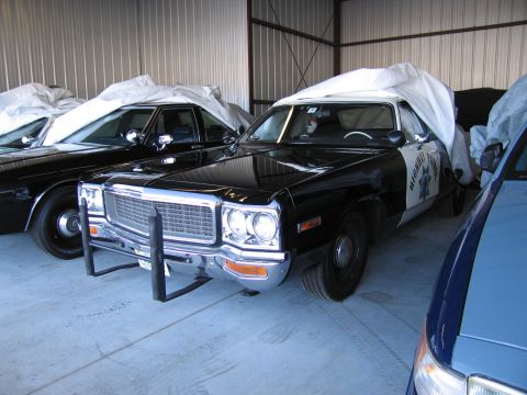 1991 Ford LTD Crown Victoria - Police car parked indoors, partially covered with a tarp, with another vehicle nearby.