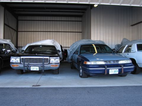 1991 Ford LTD Crown Victoria - A blue Ford Crown Victoria is parked in a garage, partially covered by a tarp.