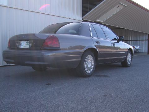 1991 Ford LTD Crown Victoria - Rear view of a 1991 Ford Crown Victoria LTD parked on asphalt near a hangar.
