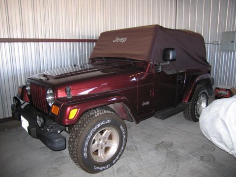 1991 Ford LTD Crown Victoria - Maroon Jeep Wrangler with a brown soft top is parked inside a garage.