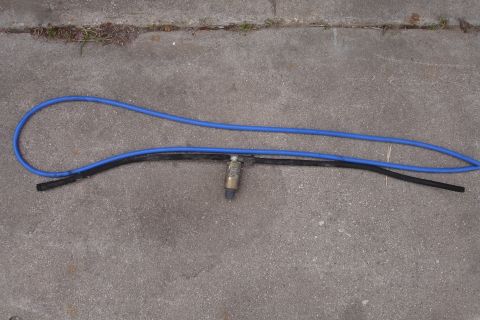 1995 Ford Taurus - A pair of silicon hoses with an attached sensor lie on a concrete surface.