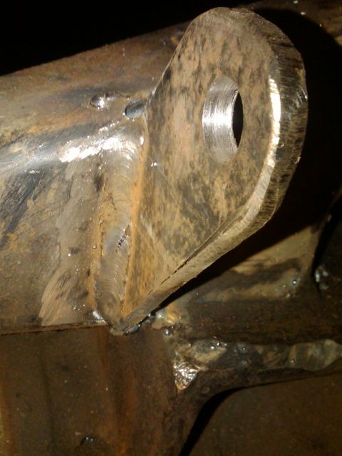 1978 Ford Bronco - This image shows a close-up view of a welded metal bracket, likely a suspension component, with visible rust and weld marks.