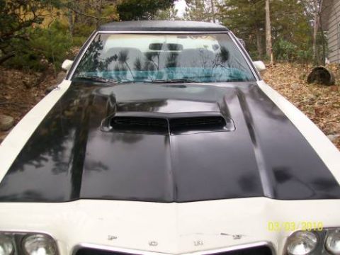 1972 Ford Ranchero - Front view of a 1972 Ford Ranchero with a black hood scoop and white body, parked outdoors.