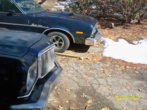 1973 Ford Ranchero - Two dark blue Ford Rancheros are parked outside, one with a GT trim package visible.
