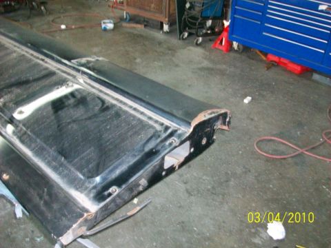 1985 Ford Bronco - A black tailgate is shown from the side in a workshop setting.