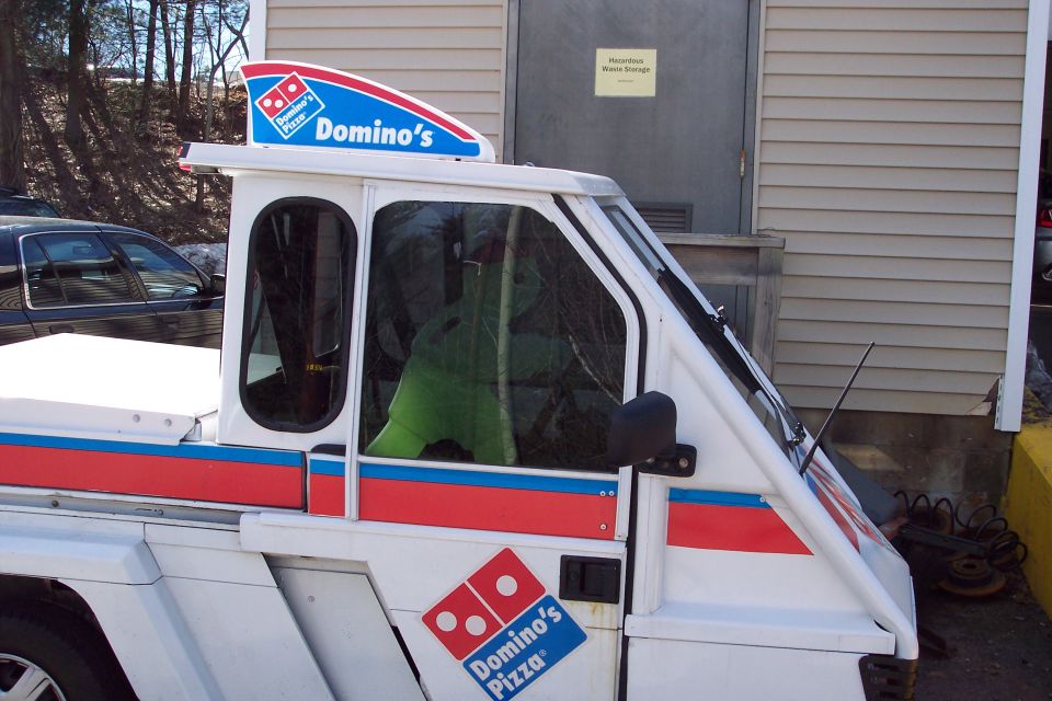 White Domino's Pizza delivery vehicle with red and blue stripes