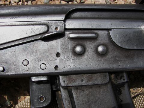 2000 Ford Crown Victoria - A detailed view of a firearm's receiver shows various stamped characters and rivets.