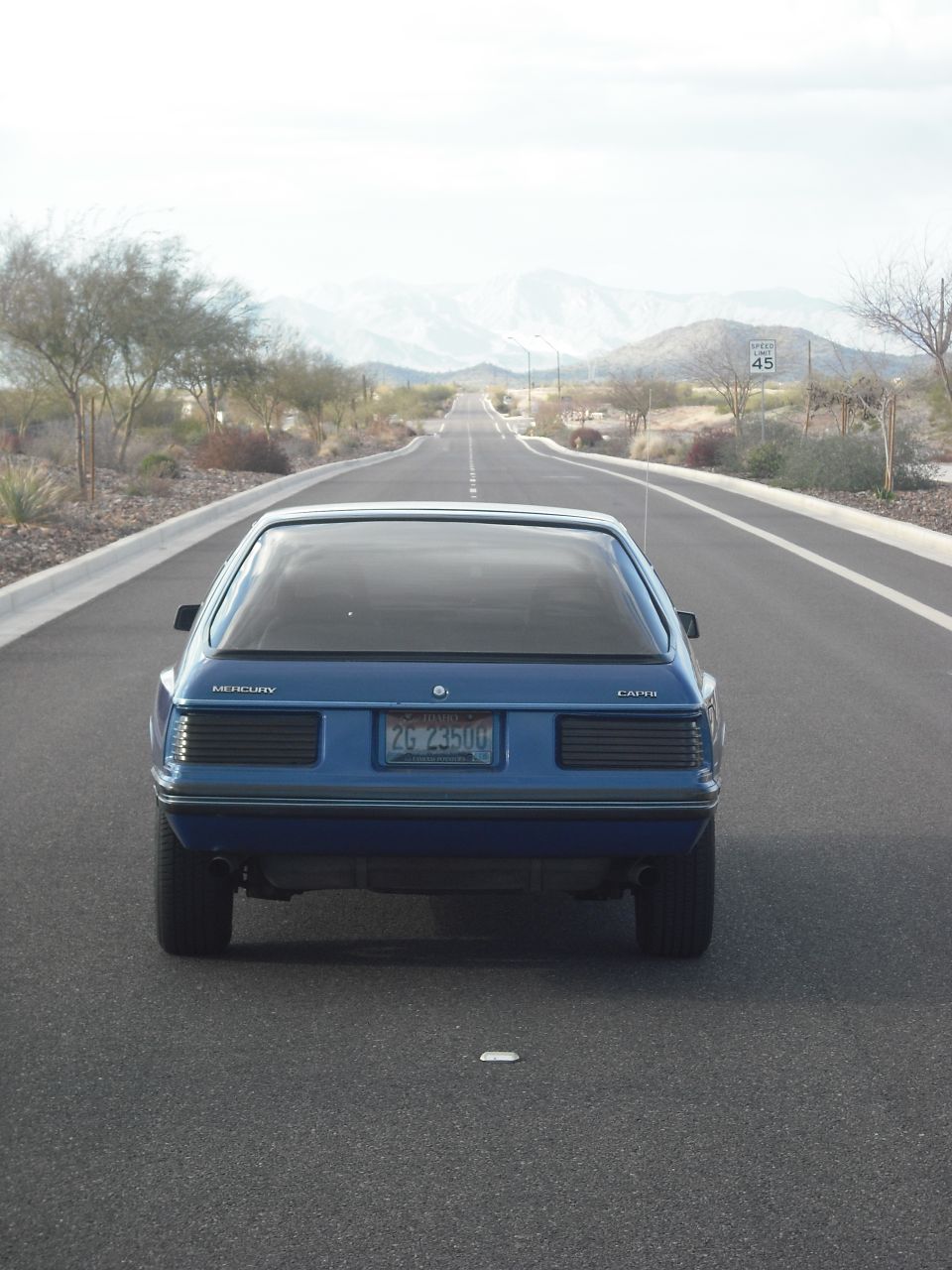 Blue 1983 Mercury Capri hatchback on a road, rear view