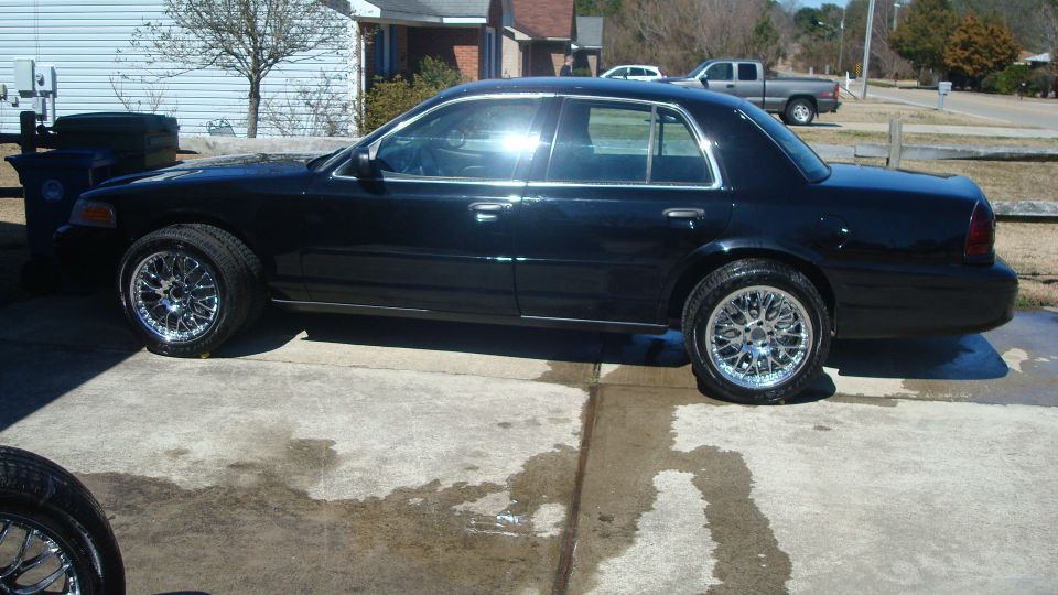 Black 2004 Ford Crown Victoria side view with custom chrome wheels