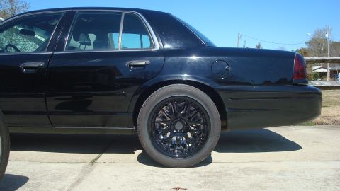2004 Ford Crown Victoria - Side profile of a black 2004 Ford Crown Victoria with custom black rims.