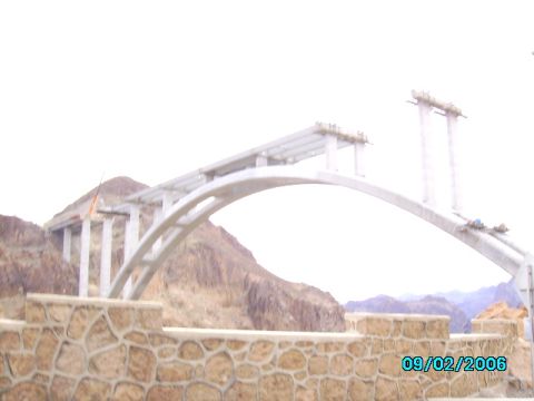 1978 Ford Bronco - Bridge construction in progress, showing concrete supports and the arch span against a mountainous backdrop.