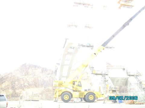 1978 Ford Bronco - A yellow crane is positioned at a construction site with mountains visible in the distance.