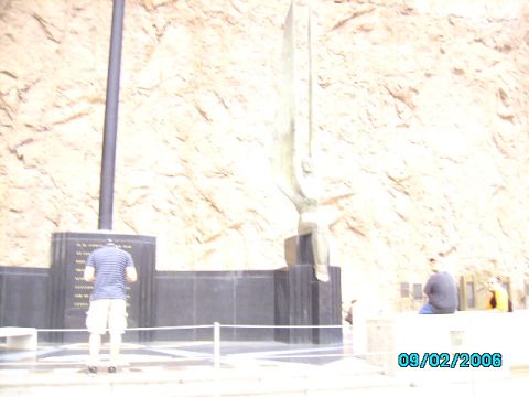 1978 Ford Bronco - A monument with a large statue and inscribed plaques is viewed with people nearby, set against a rocky cliff face.