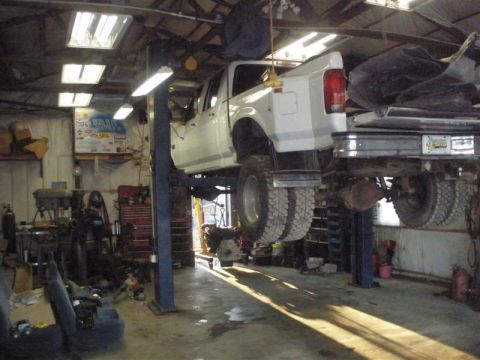 1994 Ford F-350 - White pickup truck on a lift in a garage, showing its dual rear wheels and rear 3/4 view.