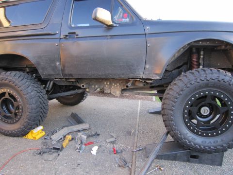 1996 Ford Bronco - Modified 1996 Ford Bronco frame and suspension components are visible, with tools scattered nearby.