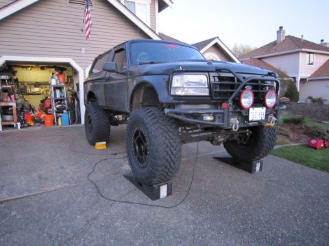 1996 Ford Bronco - This modified 1996 Ford Bronco features a lifted suspension and aggressive off-road tires, parked in a driveway.
