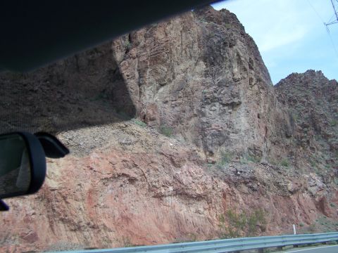 1978 Ford Bronco - Driving past a large rock formation, seen from the perspective of a car's interior.
