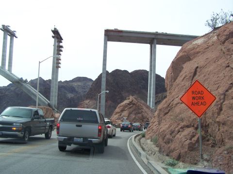 1978 Ford Bronco - Vehicles drive past a bridge under construction, with a 'Road Work Ahead' sign visible.