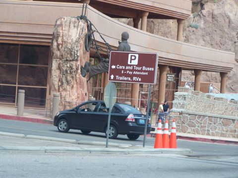 1978 Ford Bronco - A black sedan drives past a parking sign for cars, tour buses, trailers, and RVs at the Hoover Dam Store.