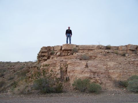 1978 Ford Bronco - A person stands atop a rocky outcrop in a desert landscape.