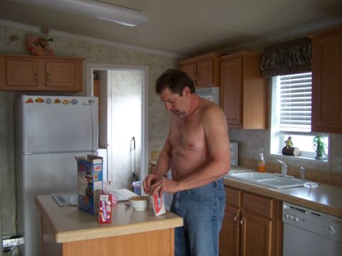 1978 Ford Bronco - A man prepares his breakfast in a kitchen setting, with a refrigerator and cabinets visible.