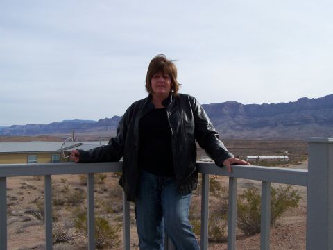 1978 Ford Bronco - A woman stands on a balcony overlooking a desert landscape with mountains in the distance.
