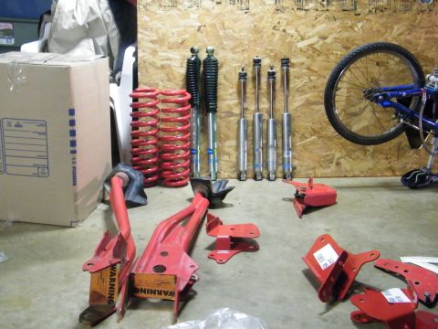 1982 Ford Bronco - Various vehicle suspension components and brackets are displayed, along with a bicycle wheel.