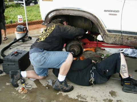1982 Ford Bronco - Two mechanics are working on the rear suspension of a 1982 Ford Bronco.