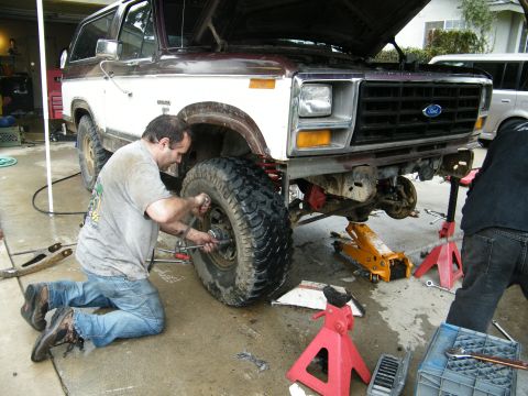 1982 Ford Bronco - Working on the front wheel hub of a lifted 1980s Ford Bronco, which is supported by jack stands.