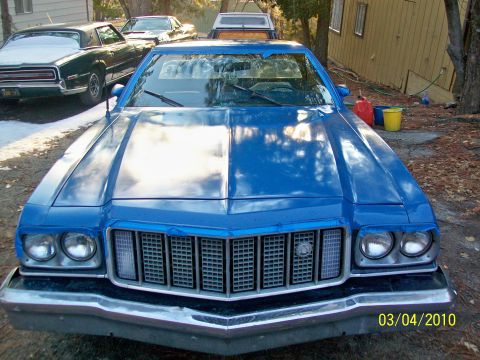 1973 Ford Ranchero - The front of a blue 1974 Ford Ranchero is shown, with other vehicles in the background.