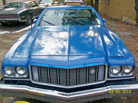 1973 Ford Ranchero - A blue 1974 Ford Ranchero is parked in front of a building, with another car visible behind it.