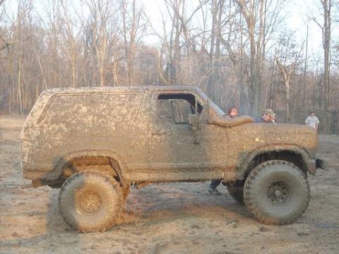 1979 Ford Bronco - This heavily mud-caked 1979 Ford Bronco is shown from the side, equipped with oversized off-road tires.