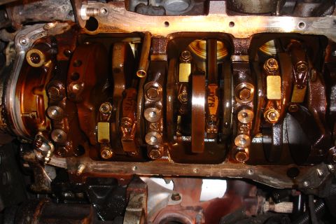 1993 Ford Taurus - Close-up view of an engine's internal components, showing the crankshaft and connecting rods coated in oil.