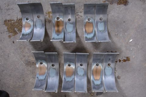 1993 Ford Taurus - Several engine bearing shells show wear and discoloration, indicating potential engine issues.