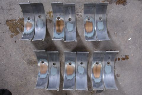 1993 Ford Taurus - Engine bearings show signs of wear and damage, indicating potential mechanical issues.