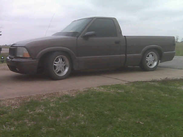 Lowered gray GMC Sonoma regular-cab pickup on a driveway with polished five-spoke wheels