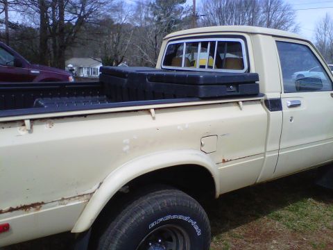 1981 Toyota Hilux - Side view of a 1981 Toyota Hilux pickup truck with a black toolbox in the bed.