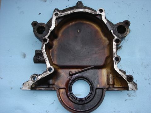 1992 Ford Bronco - This is a close-up of a used engine timing cover, showing signs of wear and oil residue.