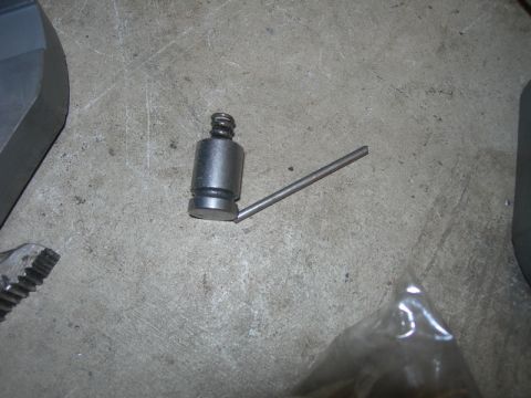 1991 Jeep Wrangler - A metal part, possibly a tool or component, rests on a concrete surface.