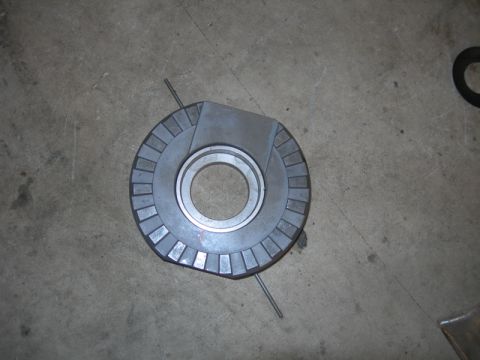 1991 Jeep Wrangler - A metal disc part with a serrated outer edge and a central bearing is shown on a concrete floor.