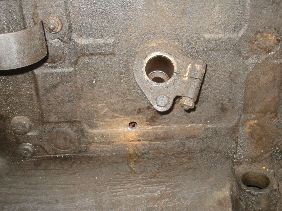 Close-up of a rusty cast engine block with a bracket