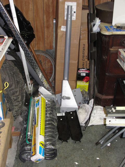 1995 Ford Bronco - Collection of vehicle parts and storage items in a cluttered space.